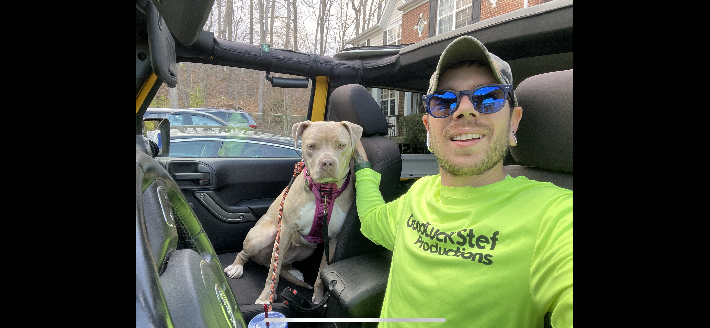 Stefan smiling beside a dog outdoors